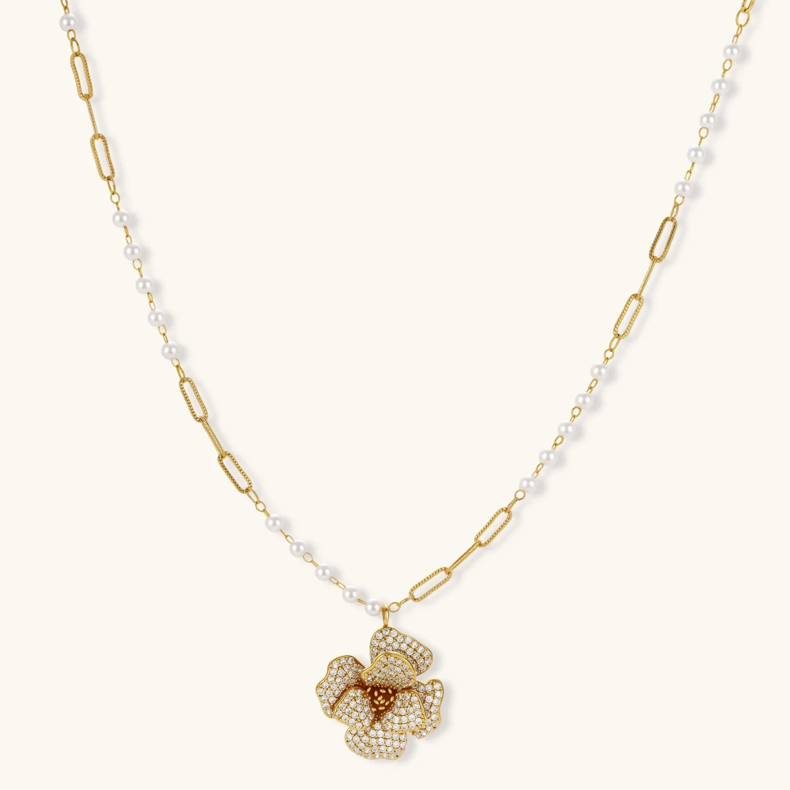14K gold-plated floral jewelry set with blue cubic zirconia centers and pearl chain details on white background.
