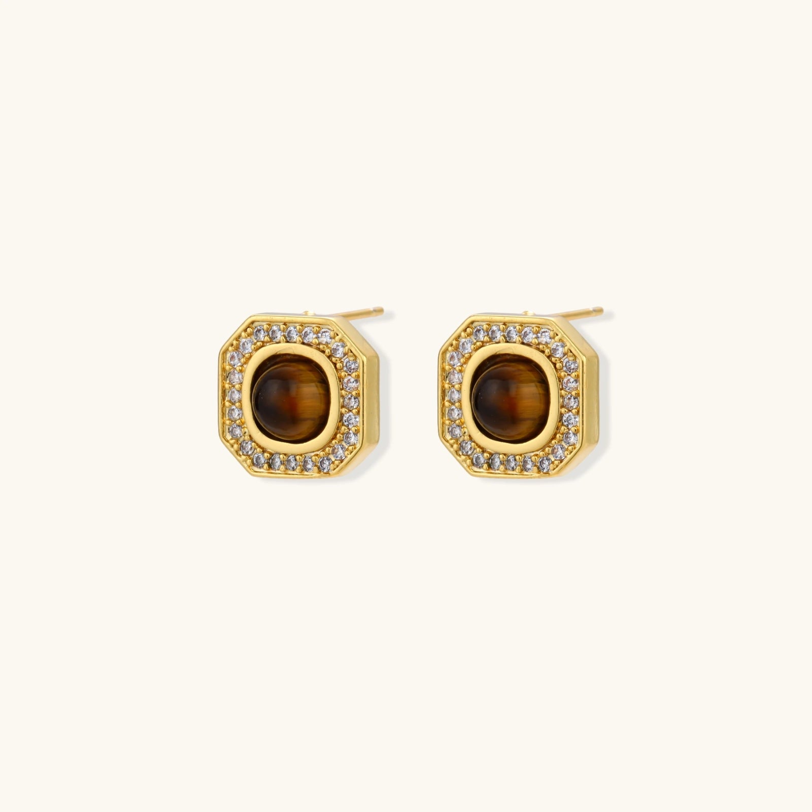 Gold-plated octagonal stud earrings with brown tiger's eye centers and cubic zirconia border on cream background.
